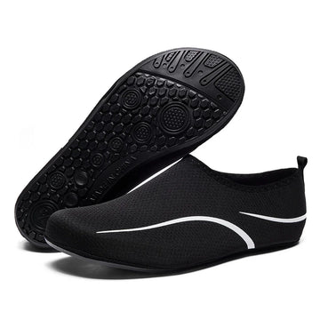 Black mesh slip-on sneakers with white accents and flexible rubber sole, minimalist design.