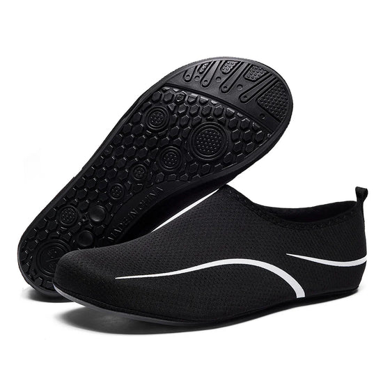 Black mesh slip-on sneakers with white accents and flexible rubber sole, minimalist design.