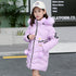 Girl wearing a light purple puffer coat with faux fur hood, heart sleeve detail, and pom-poms