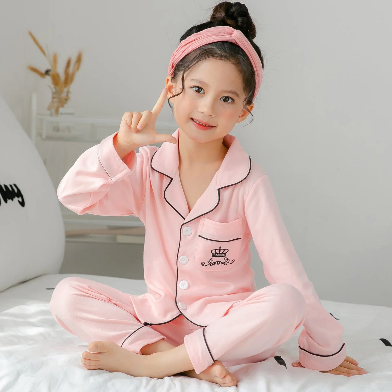 Girl in pink long-sleeve pajama set with contrast piping, soft cotton material, relaxed fit