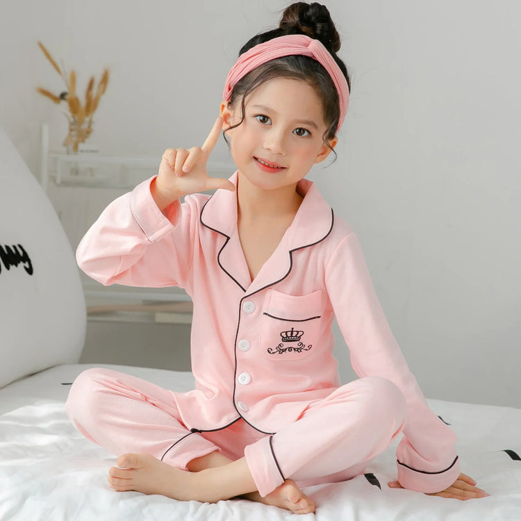 Girl in pink long-sleeve pajama set with contrast piping, soft cotton material, relaxed fit