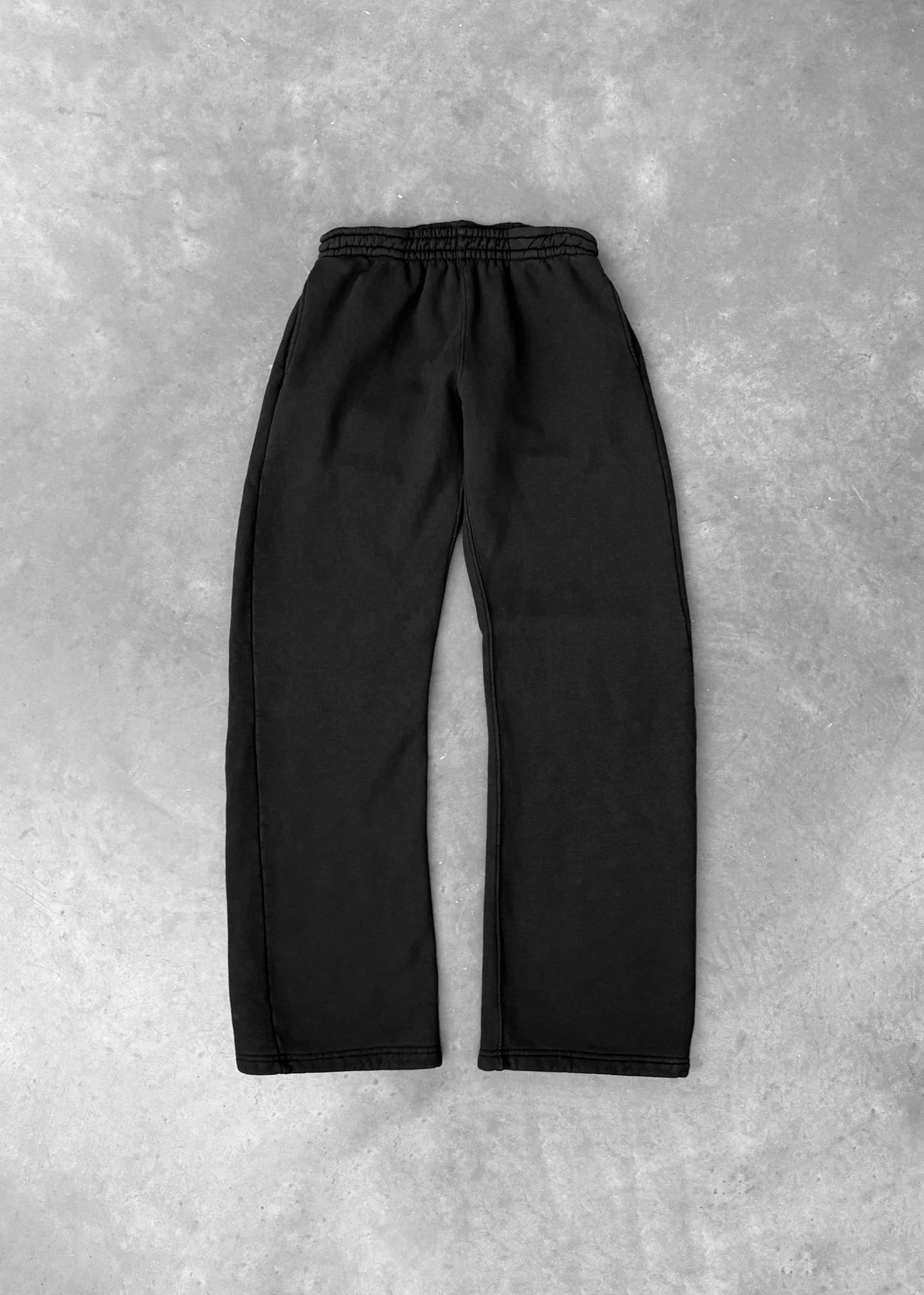 Black relaxed fit sweatpants with elastic waistband, soft cotton material, flat lay