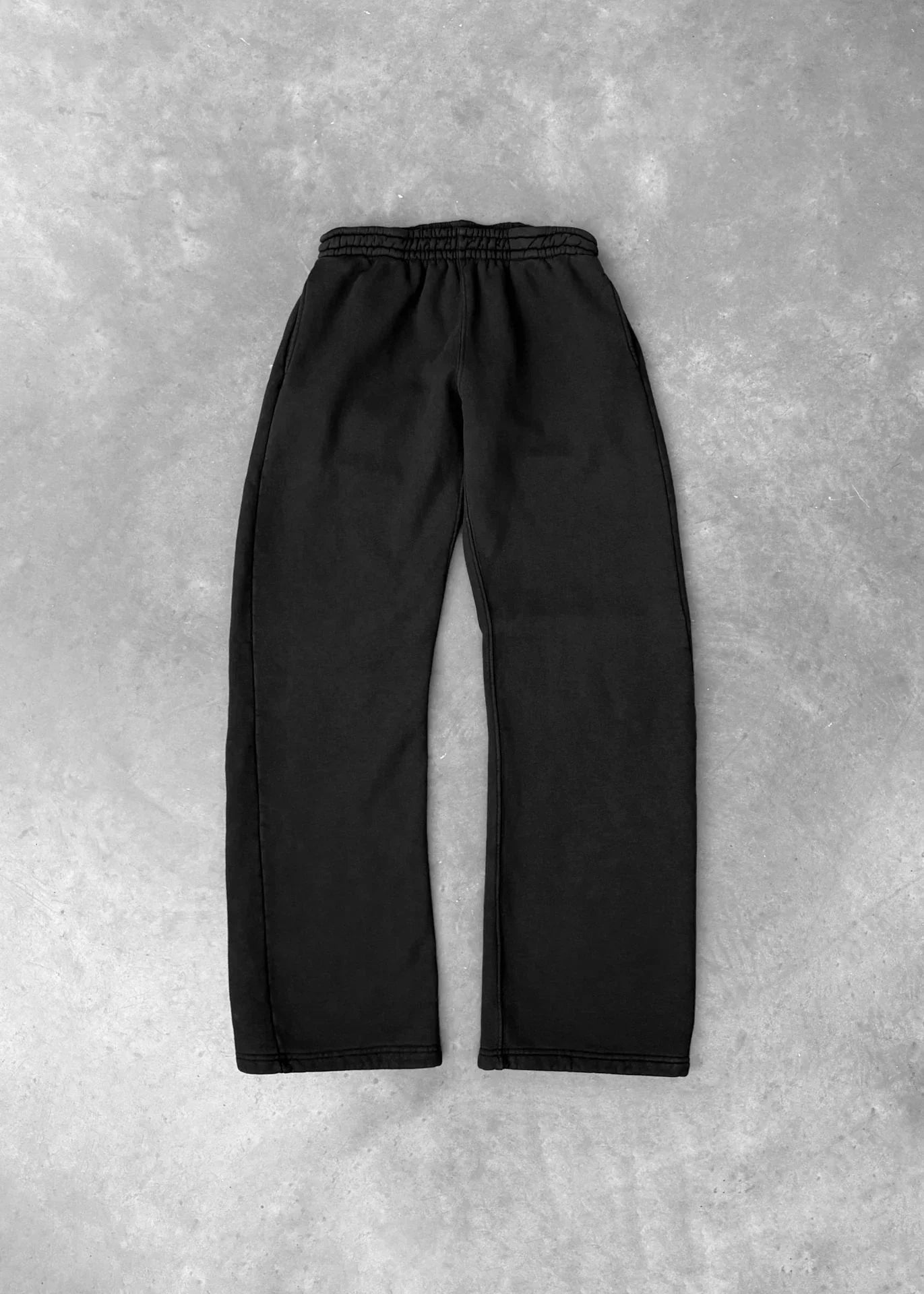 Black relaxed fit sweatpants with elastic waistband, soft cotton material, flat lay