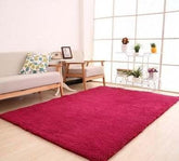 Modern living room with plush red area rug, light sofa, and natural wood furniture