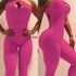 Textured hot pink bodycon jumpsuit with halter neck and cutout detail, form-fitting style