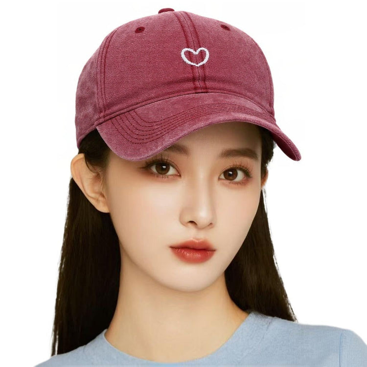 Woman wearing a retro small love embroidered soft top cotton peaked cap in wine red color