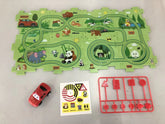 Colorful animal-themed playmat with winding green tracks, red toy car, traffic signs, and stickers