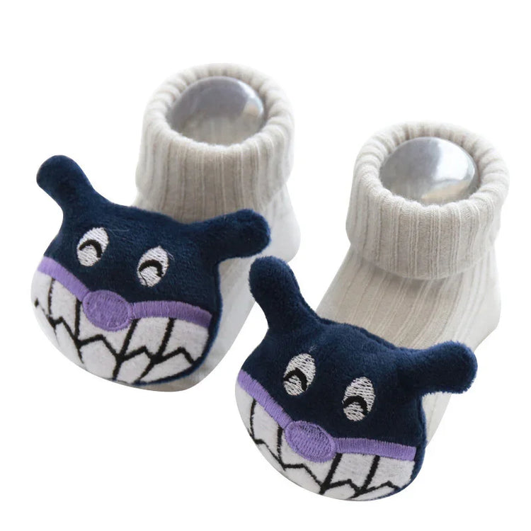 White ribbed baby booties with soft navy cartoon face and grinning teeth design on toes