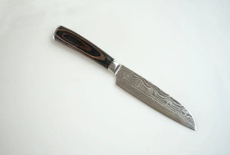 Damascus steel kitchen knife with patterned blade and wood grain handle on white background