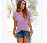 Woman wearing casual lavender fringe sleeve top and distressed denim shorts outdoors