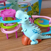 Pastel dinosaur-themed toy racetrack with blue, pink, and green spiral rails on wood surface