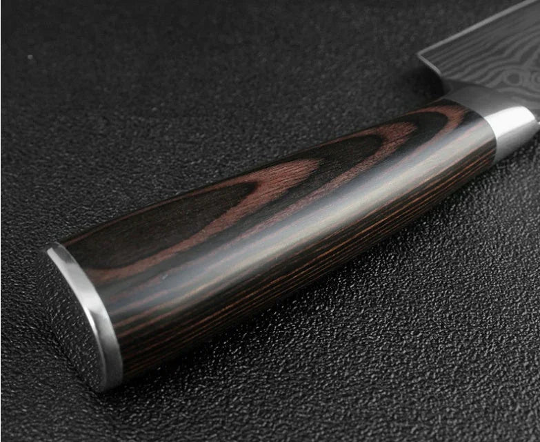 Close-up of a polished dark wood knife handle with metal accents on a textured surface