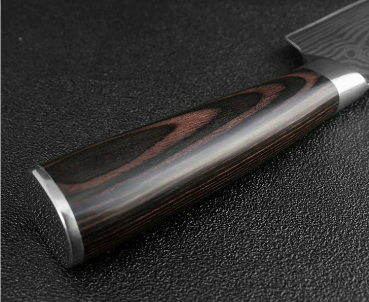 Close-up of a polished dark wood knife handle with metal accents on a textured surface