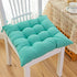 Turquoise cotton seat cushion with tufted design on white wooden chair, casual home decor