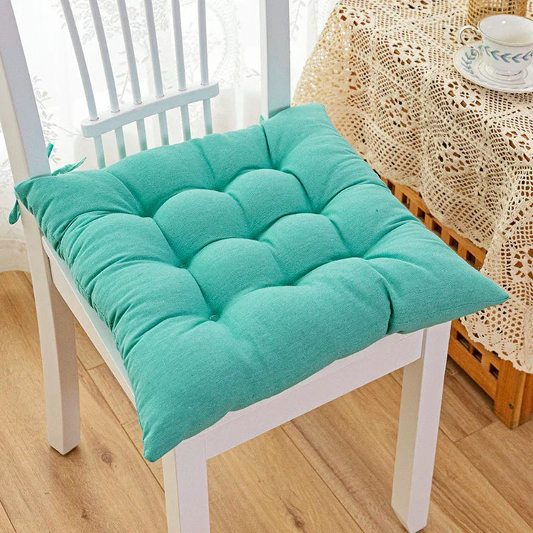 Turquoise cotton seat cushion with tufted design on white wooden chair, casual home decor
