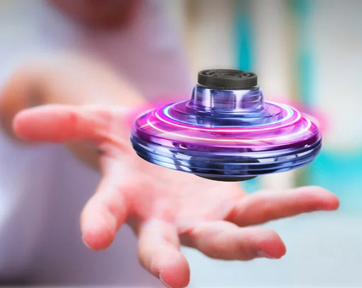 Hand spinning a purple LED flying spinner toy, futuristic transparent plastic material.