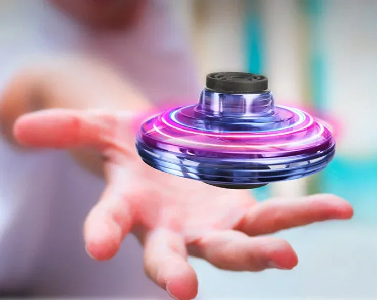 Hand spinning a purple LED flying spinner toy, futuristic transparent plastic material.