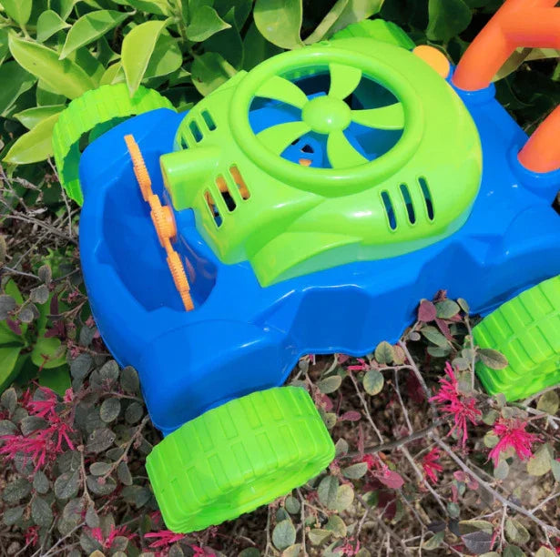 Blue and green plastic toy car with large wheels and fan detail, outdoors on leafy plants