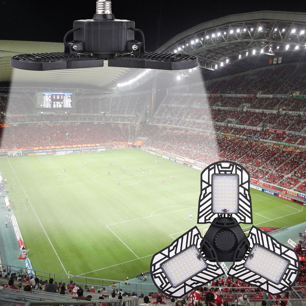 Adjustable LED stadium light with three black panels illuminating a crowded soccer field