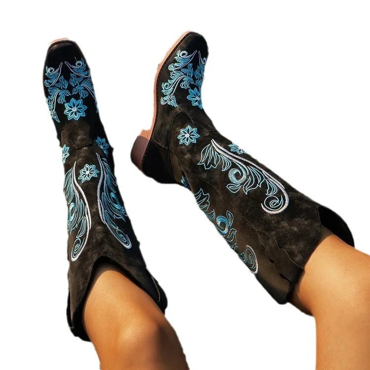 Black suede cowboy boots with blue floral embroidery, mid-calf length, bold streetwear style