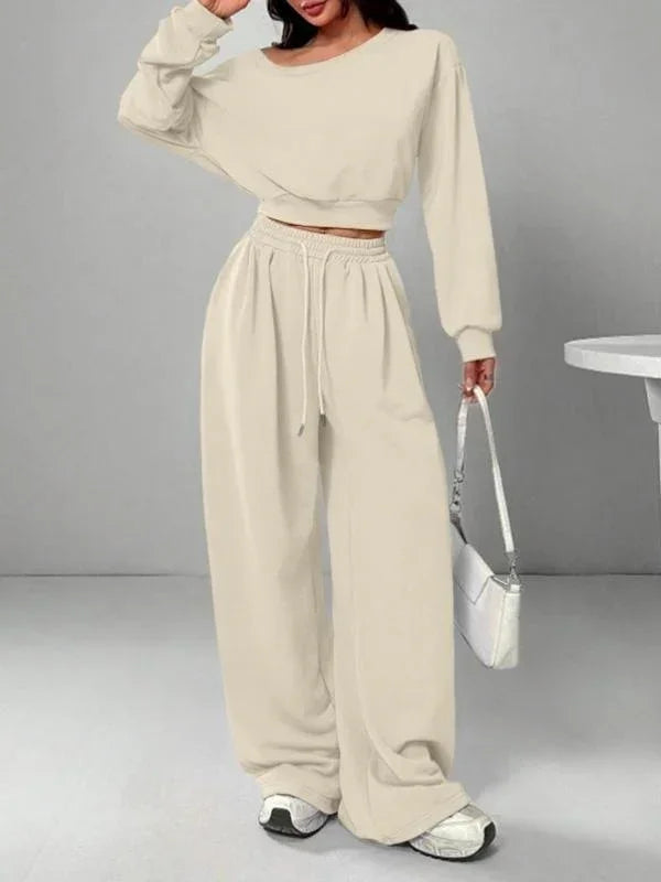 Woman wearing beige oversized lounge set with drawstring pants and long sleeve crop top