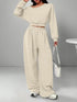 Woman wearing beige oversized lounge set with drawstring pants and long sleeve crop top