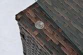 Close-up of brown woven rattan table corner with glass top and clear rubber pad
