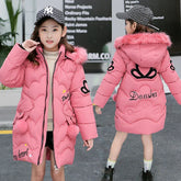 Girl in long pink puffer coat with faux fur hood, heart patches, relaxed fit, streetwear style