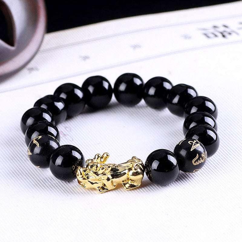Black beaded bracelet with glossy finish and gold dragon charm, modern streetwear accessory