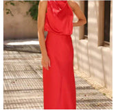 Woman wearing a red satin sleeveless maxi dress with draped neckline and slim fit