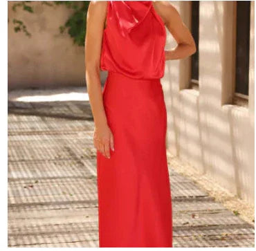 Woman wearing a red satin sleeveless maxi dress with draped neckline and slim fit