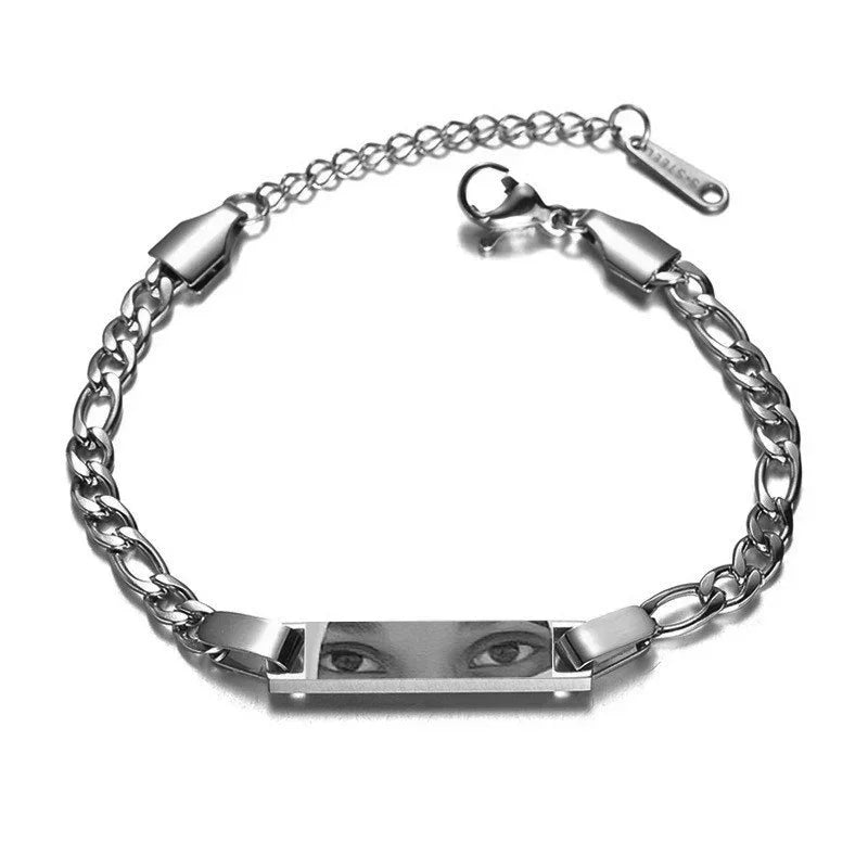 Silver chain bracelet with engraved rectangular plate featuring realistic eye artwork, adjustable fit