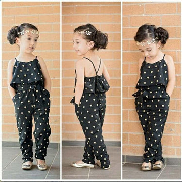 Girl wearing black heart print jumpsuit with ruffle top and adjustable straps, relaxed fit