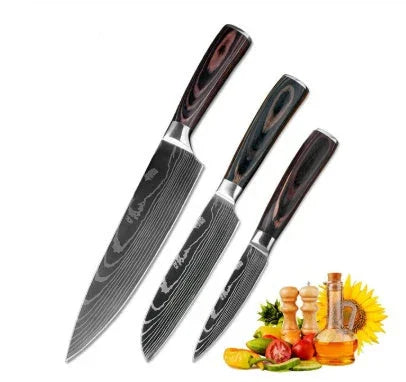 Set of three stainless steel kitchen knives with dark wooden handles, displayed with fresh vegetables and cooking condiments.