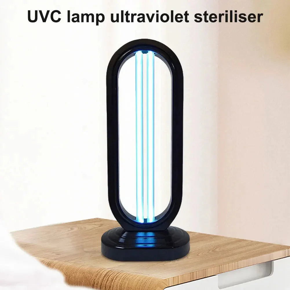 Black oval UVC ultraviolet steriliser lamp with blue light on wooden table