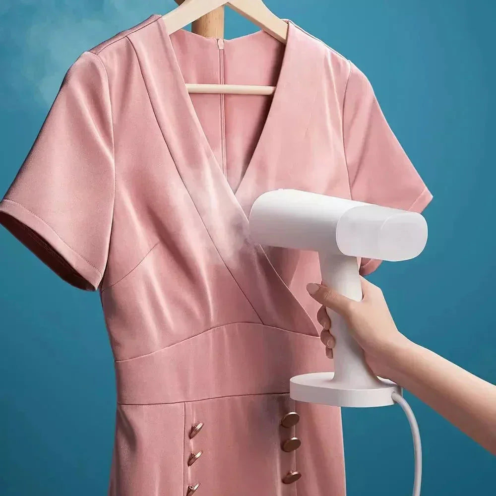 Pink satin short sleeve dress being steamed, v-neck, fitted waist, soft sheen