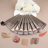 Set of taupe makeup brushes with soft synthetic bristles, arranged on beige background.