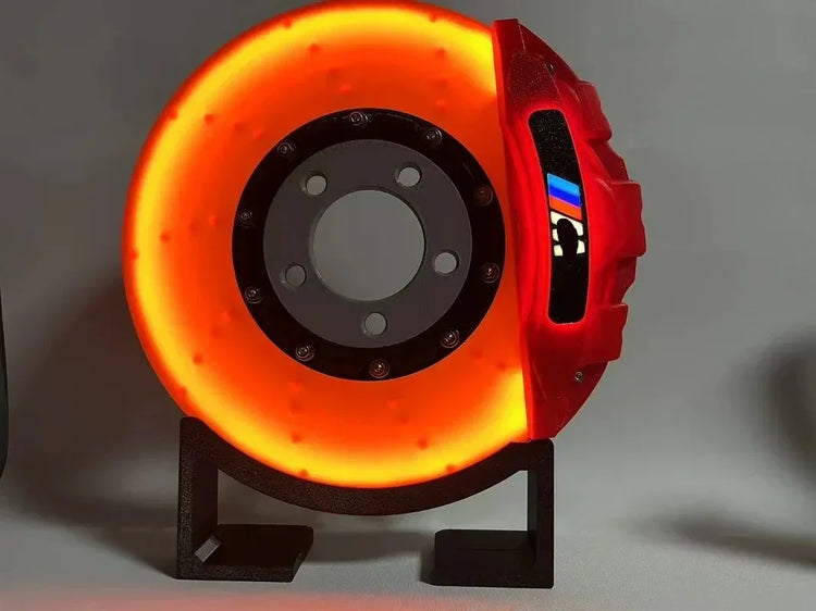 Futuristic orange and red LED disc brake lamp with metallic finish on black stand