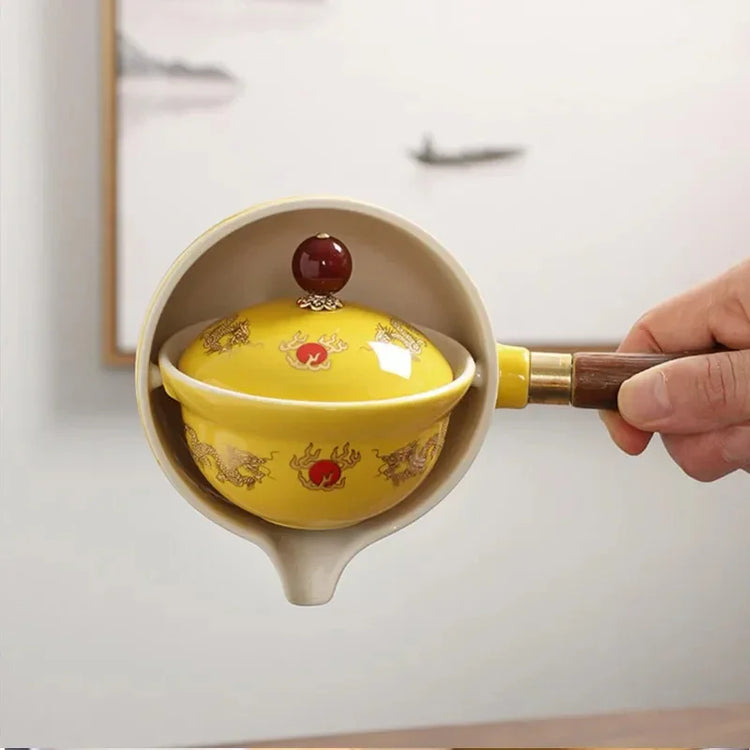 Yellow ceramic tea pot with wooden handle, dragon motif, glossy finish, traditional style.