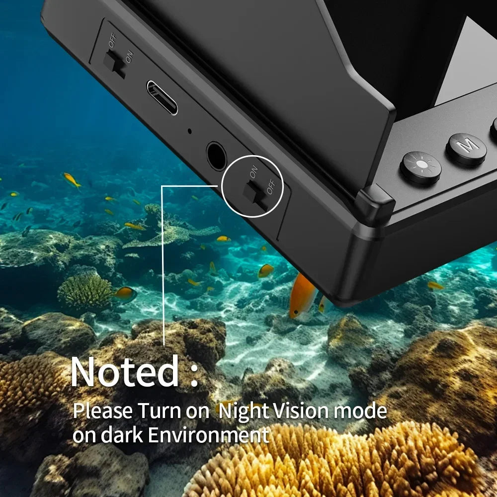 Close-up of a black electronic device with night vision switch, shown underwater above coral reef.
