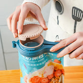 Person in a white sweater with kitchen utensil print, opening a resealable food storage bag