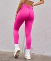 Bright pink high-waisted leggings with ruched back, stretchy fabric, slim fit, paired with white sneakers