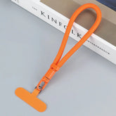Orange nylon tech accessory lanyard with clip, modern minimalist style, on grey surface