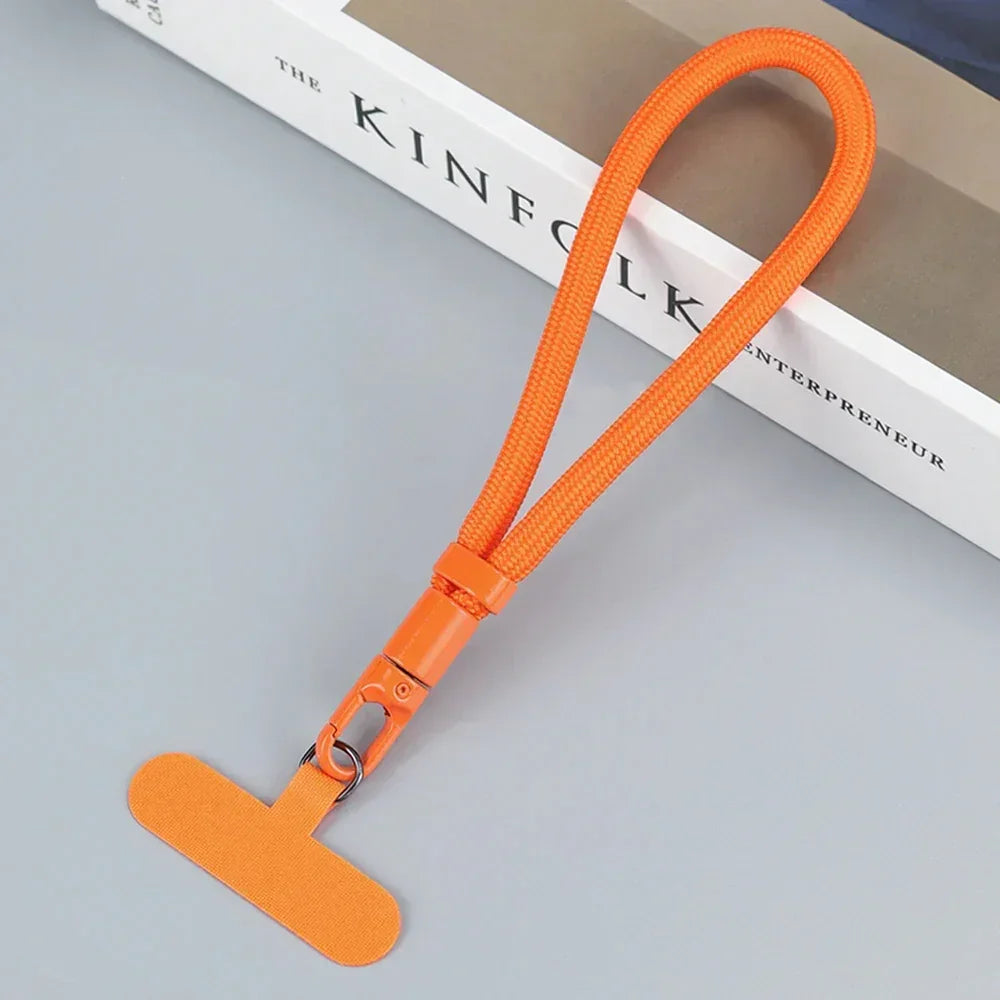 Orange nylon tech accessory lanyard with clip, modern minimalist style, on grey surface