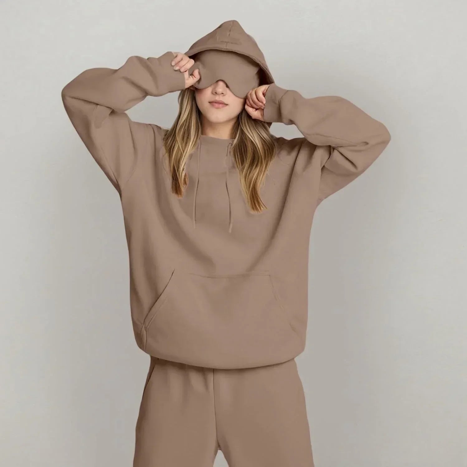 Woman in oversized beige hoodie and sweatpants set with relaxed fit, minimalist streetwear style