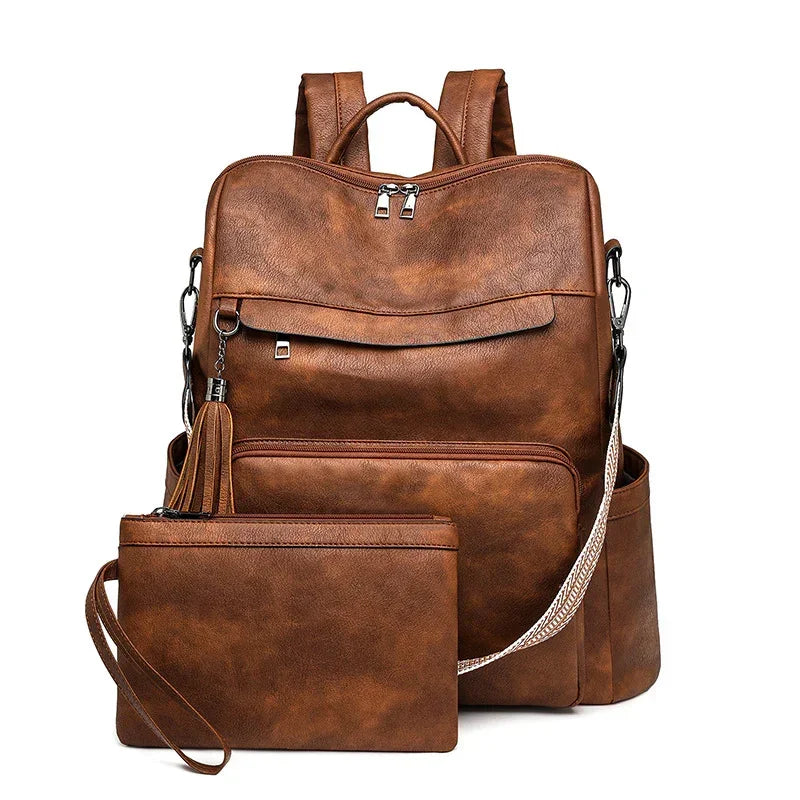 Brown faux leather backpack and matching wristlet pouch with zipper pockets and adjustable straps