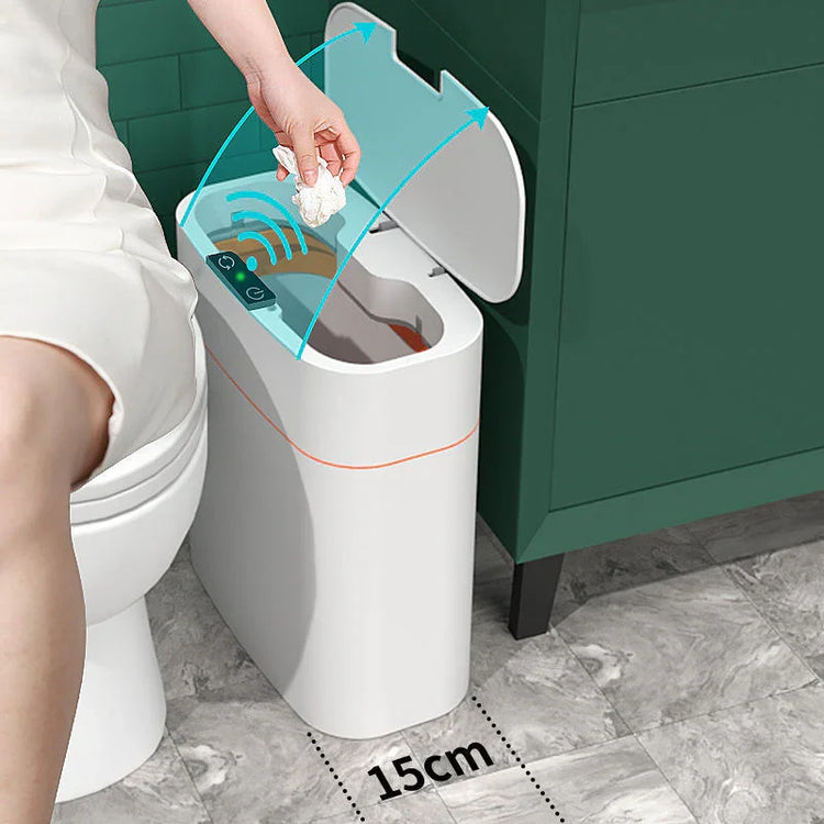 Woman in white dress using a sensor automatic trash can with touchless lid in modern bathroom.