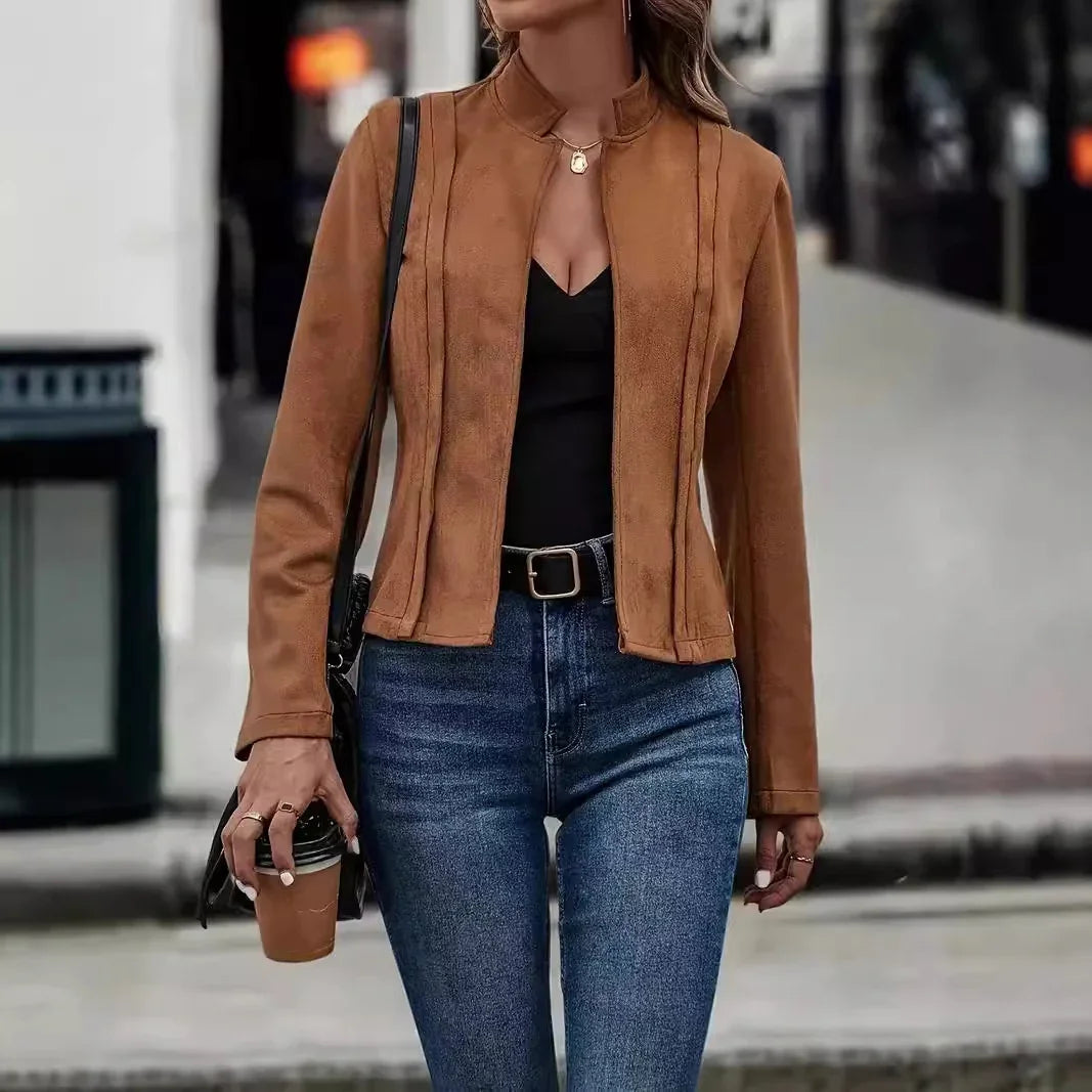 Woman wearing a fitted brown suede jacket, black top, and high-waisted blue jeans.