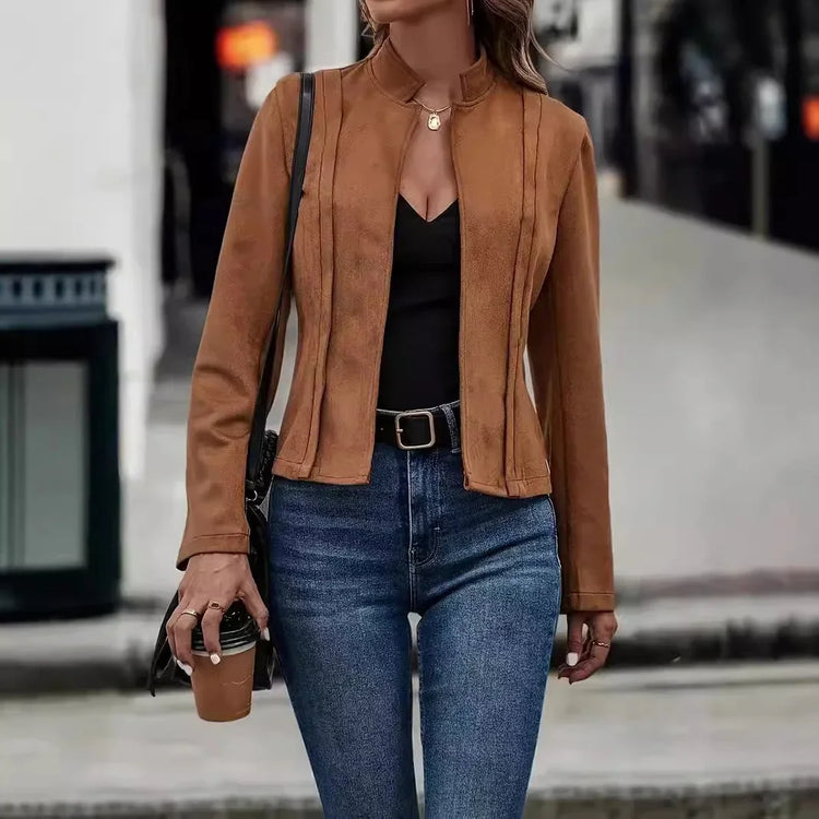 Woman wearing a fitted brown suede jacket, black top, and high-waisted blue jeans.
