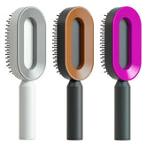 Three futuristic oval hair brushes in gray, brown, and magenta with ergonomic handles